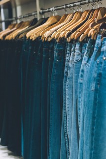 Jeans hanging on a rack in a store. Copy space. Vertical shot