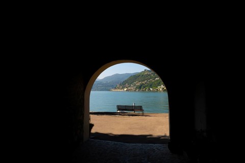 Old Beautiful Street Tunnel with Arch and a Bench From Brusino Arsizio on the Waterfront in a Sunny Summer Day and with Lake Lugano and Mountain View over Morcote
