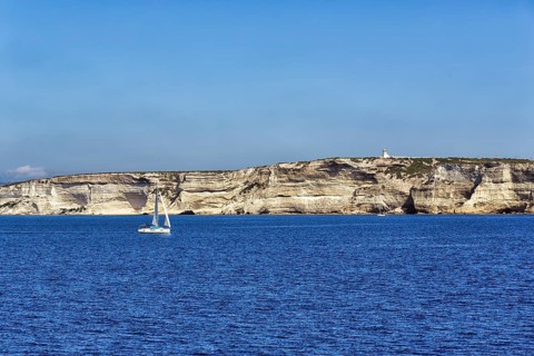 Sailboat in front of white chalk cliffs