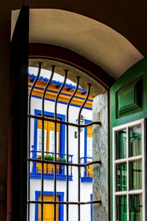 Historic colonial style house seen through the window of a church in the city of Mariana in the state of Minas Gerais