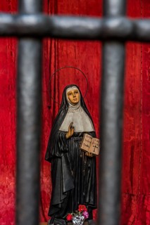 Model of a praying nun behind bars