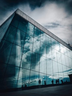 Silhouettes reflected in the façade of the opera house in Oslo
