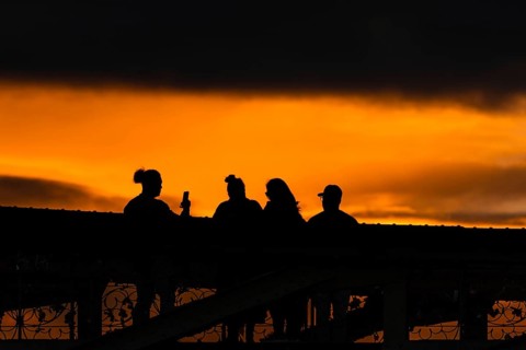 Passers-by watching and photographing the sunset from the Eiserner Steg in Frankfurt am Main