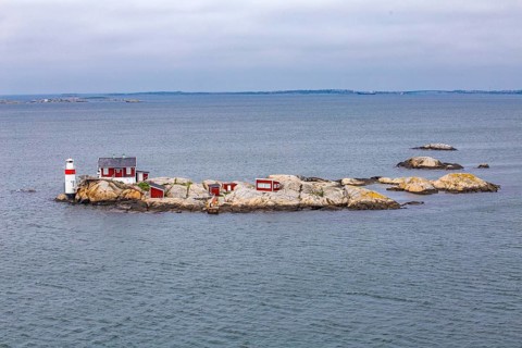 Typical tiny archipelago island with lighthouse and lighthouse keeper's house