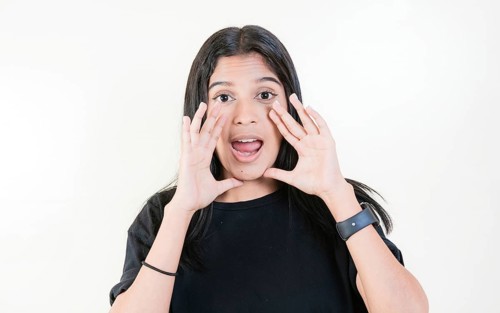 Young girl announcing something to the camera. Young woman screaming and announcing at the camera