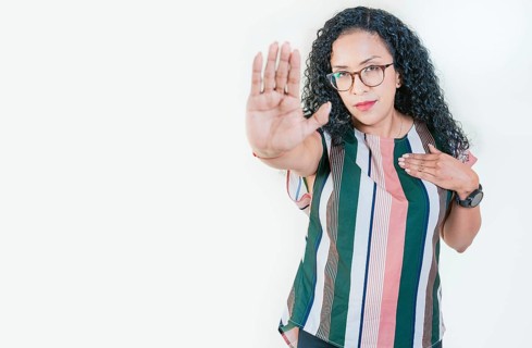Young afro woman rejecting with the palm hand isolated. Afro girl gesturing stop isolated. Latin girl gesturing stop with palm hand isolated