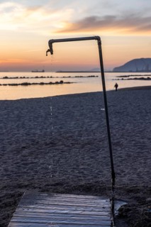 Dripping shower at sunset on the beach