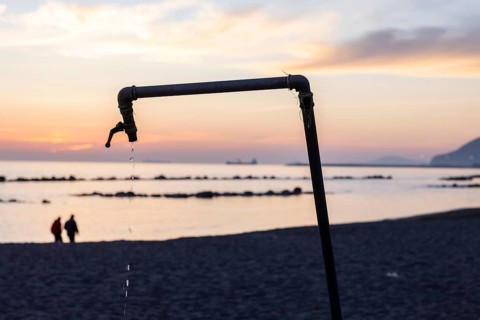 Dripping shower at sunset on the beach