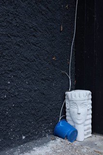 Bizarre still life with a sphinx from the hardware store and a blue bucket