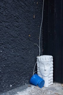 Bizarre still life with a sphinx from the hardware store and a blue bucket