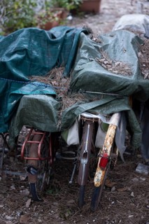 Rusty bicycles covered with a tarpaulin at an out-of-season campsite
