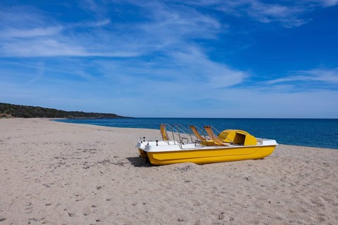 Yellow pedal boat on the beach with blue sky and blue sea