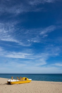 Yellow pedal boat on the beach with blue sky and blue sea