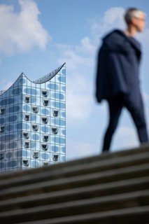 Silhouettes of people on the harbour promenade in front of the Elbe Philharmonic Hall