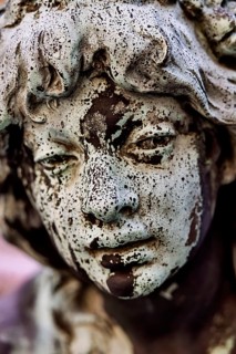 Weathered face of a figure at the Hygieia fountain in the town hall courtyard