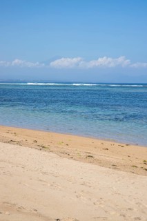 Sunrise on the sandy beach. Landscape shot with a view of the sea and the beach. Waves of light and a morning atmosphere that only exists in Sanur