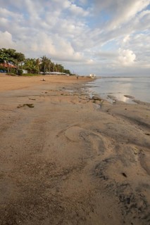 Sunrise on the sandy beach. Landscape shot with a view of the sea and the beach. Waves of light and a morning atmosphere that only exists in Sanur