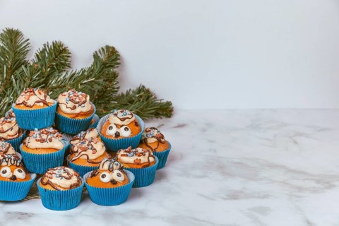 Muffins in blue ramekins with chocolate icing and sugar sprinkles
