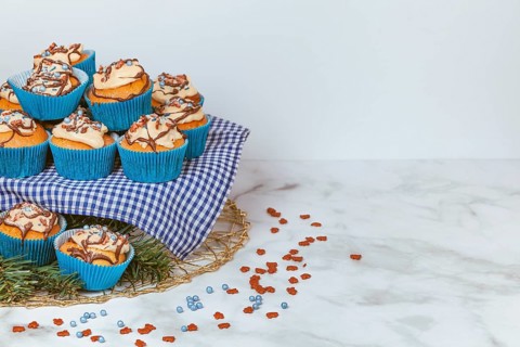Cupcakes in blue ramekins with chocolate icing and sugar sprinkles