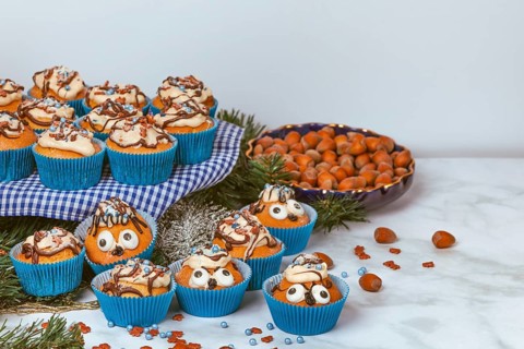 Cupcakes in blue ramekins with chocolate icing and sugar sprinkles