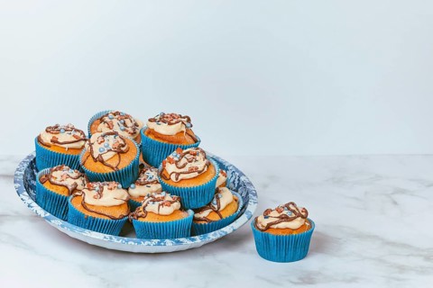 Cupcakes in blue ramekins with chocolate icing and sugar sprinkles