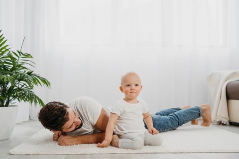 Baby standing floor home with father