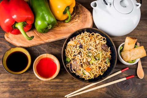 Bell peppers udon noodles sauces spring rolls white desk