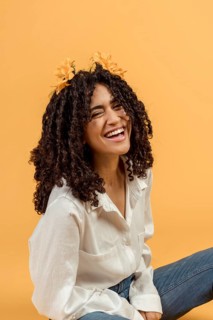 Black woman with flowers hair laughing