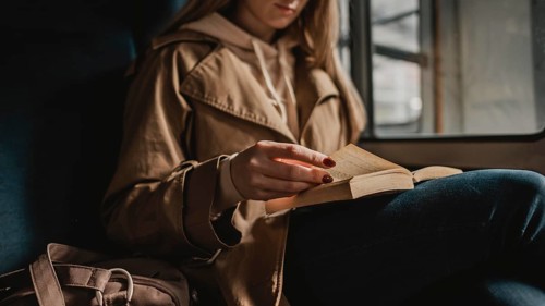 Blurred woman reading book inside train