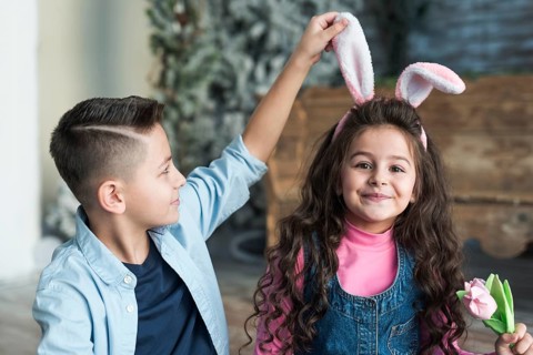Boy looking girl bunny ears with tulip