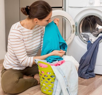 Casual woman smelling clean laundry