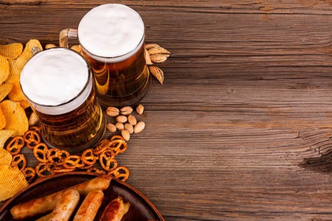 Close up beer with snacks wooden table