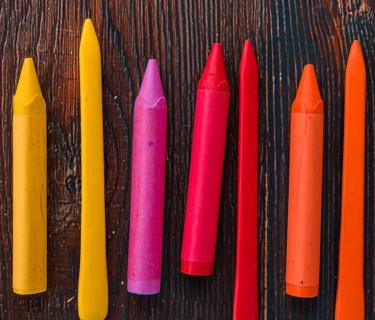 Close up colorful wax crayons wooden textured plank
