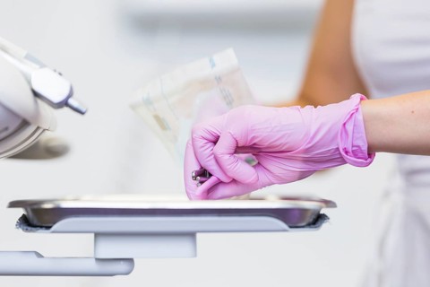 Close up dentist s hand holding dental tools