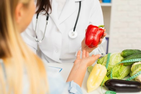 Close up doctor patient with vegetables