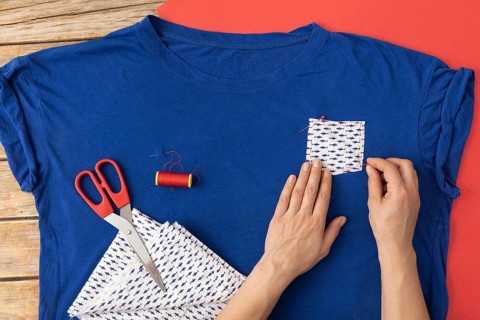 Close up hands sewing fabric shirt