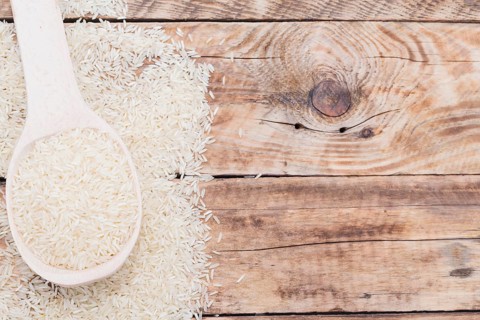 Close up raw white rice spoon textured plank