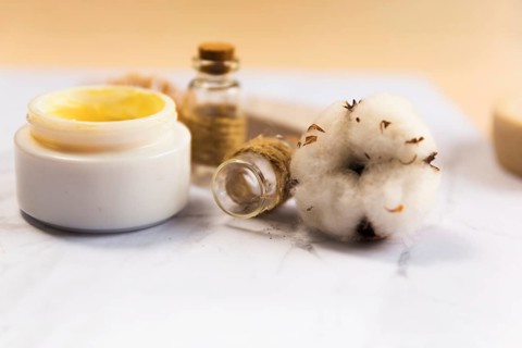 Close up spa cream bottle with cotton flower