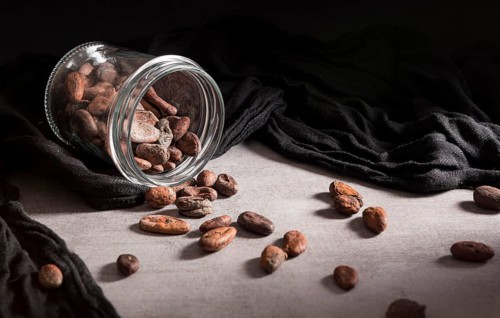 Close up spilled jar with cocoa beans