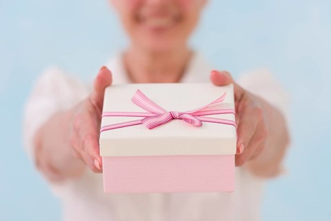 Close up woman s hand giving gift box