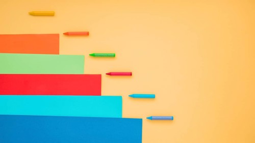 Colorful crayon craft paper arranged yellow surface