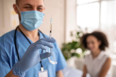 Doctor holding syringe with vaccine patient