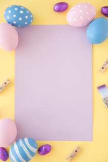 Easter eggs with blank paper yellow table