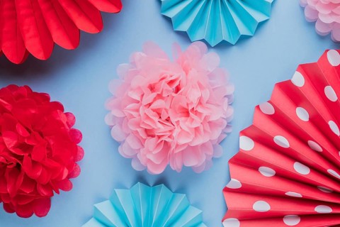 Fake beautiful decorative origami paper flowers blue surface
