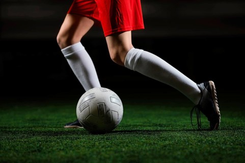 Female football player running ball