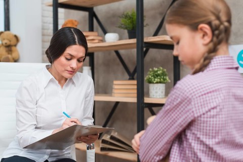 Female psychologist taking notes clipboard therapy session