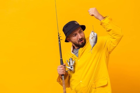 Fisherman holding fishing rod looking catch