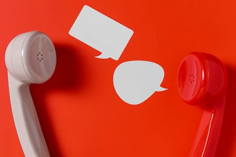 Flat lay chat bubbles with two telephone receivers
