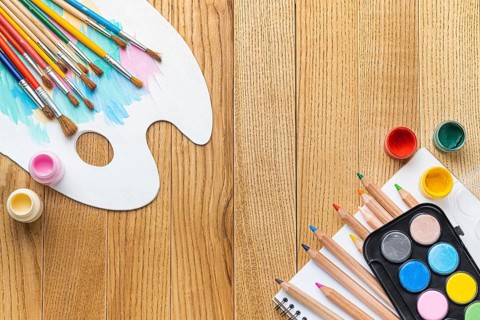 Flat lay painting essentials with brushes paint palette