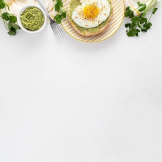 Flat lay pita with avocado spread fried egg plate with copy space